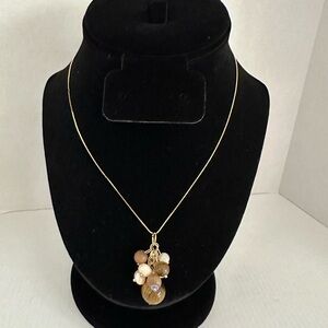 Brown and gold tone multi bead dangle pendant on gold tone metal necklace